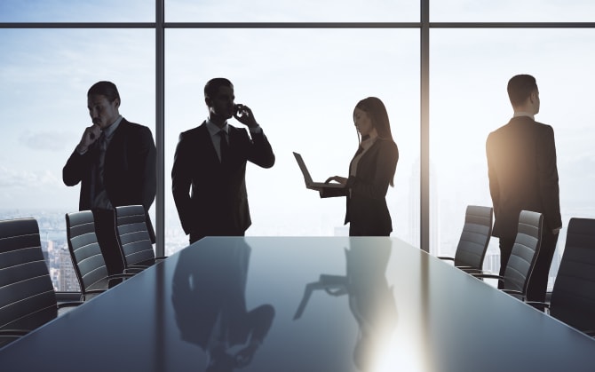会社の会議室のような場所で、各々考えごとや仕事をするビジネスマン